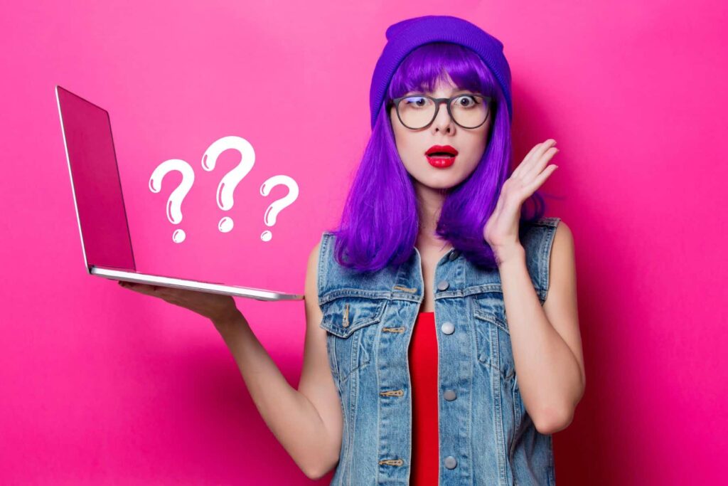 Women With Purple Hair Looking Confused And Holding Laptop.