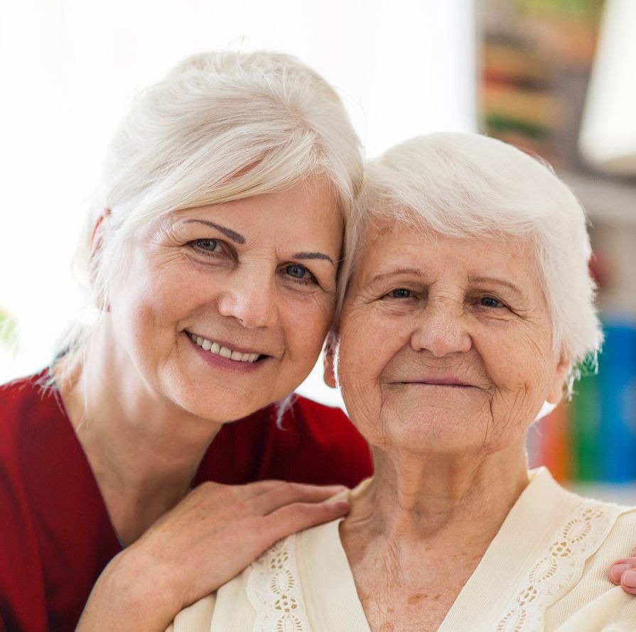 A Nurse And An Elderly Woman Smiling.