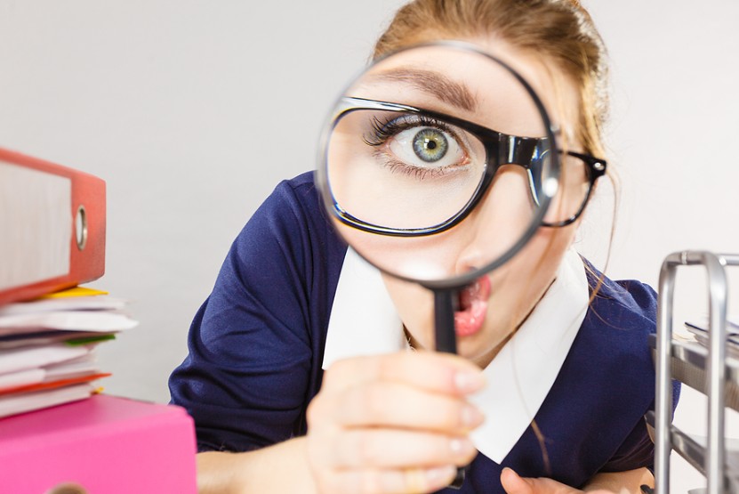 Photo Of A Women Snooping With A Magnifying Glass.