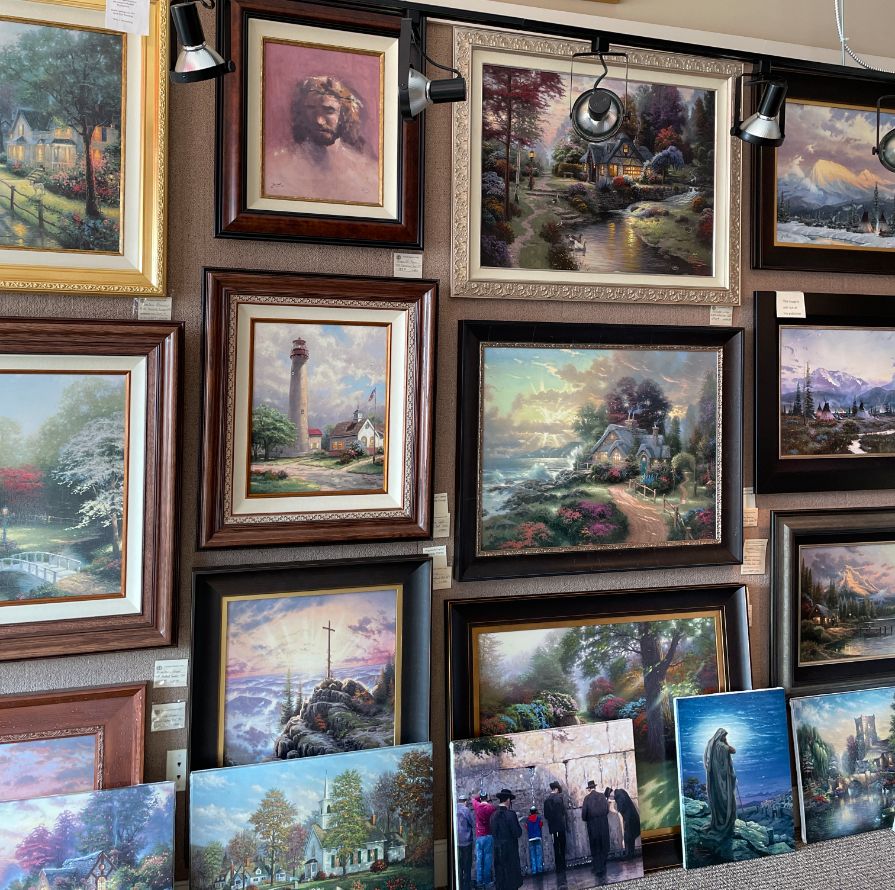 A Wall With Thomas Kinkade Paintings In The Thomas Kinkade Murfreesboro Gallery